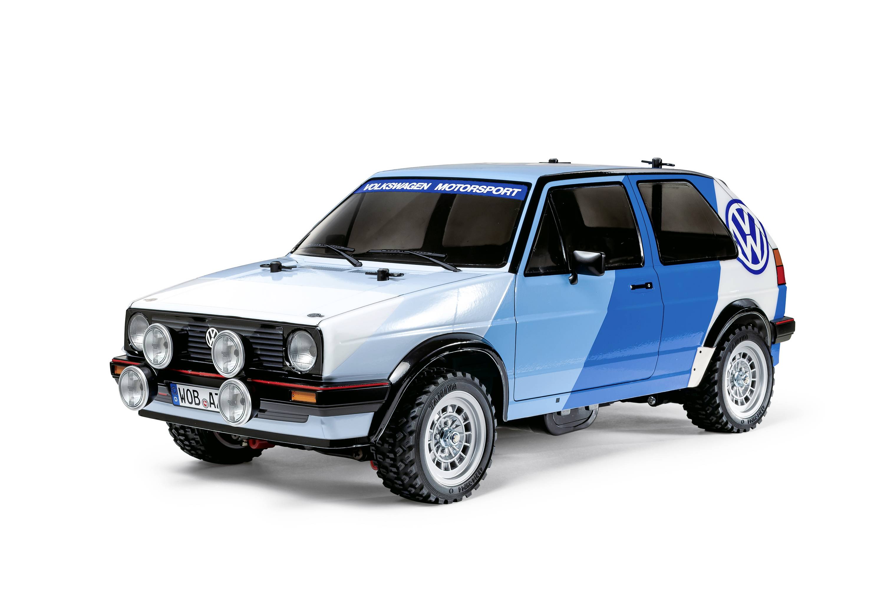 Modrý VW Golf s nápisem Motorsport a předními světlomety. Auto stojí na bílém pozadí.