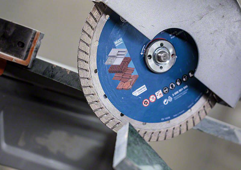 Diamantový řezný kotouč řeže skrz kámen. Kotouč je vhodný pro beton a cihly a používá se v průmyslovém prostředí.