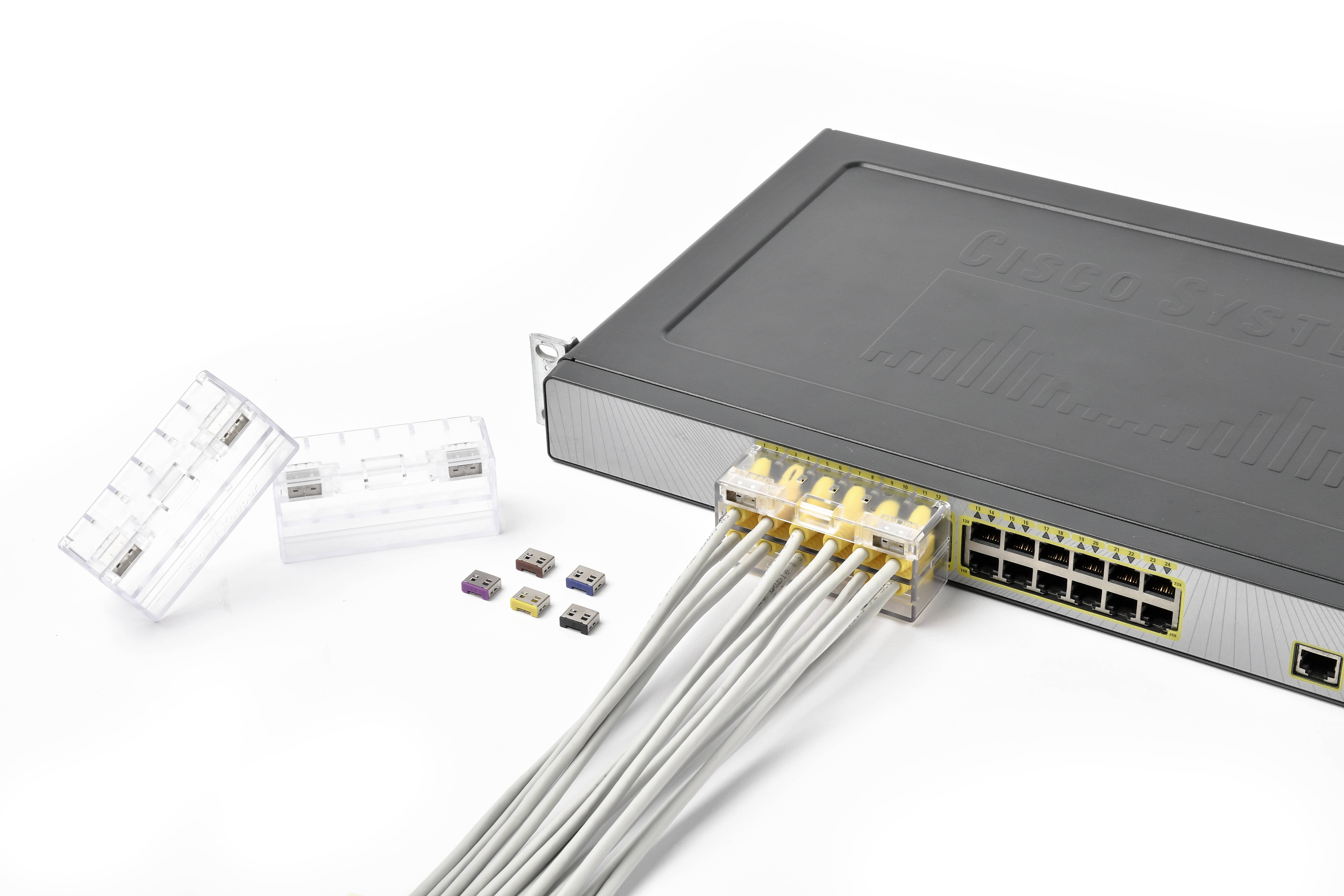 Síťový switch s osmi připojenými ethernetovými kabely a několika SIM kartami různých velikostí vedle něj.