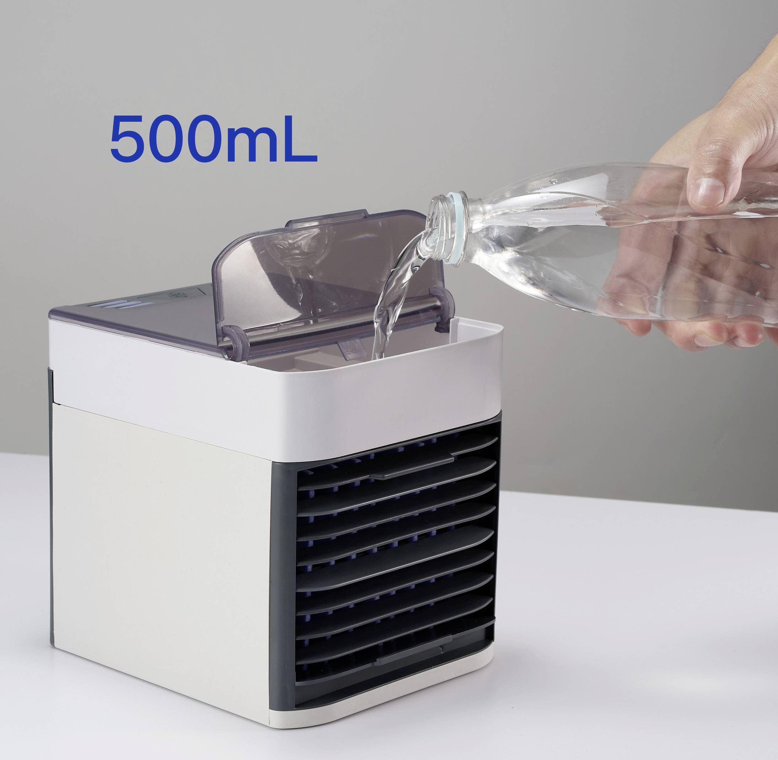 Ruka nalévá vodu z láhve do nádrže malého bílého prostorového zvlhčovače. Text '500mL' popisuje objem.