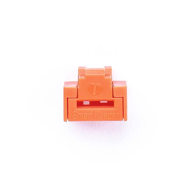 Oranžový kryt USB portu s nápisem 'Smart Keeper'.