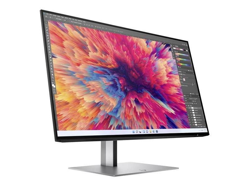 Počítačový monitor zobrazuje grafický software s barevným, abstraktním uměleckým dílem v červené, modré a oranžové barvě.