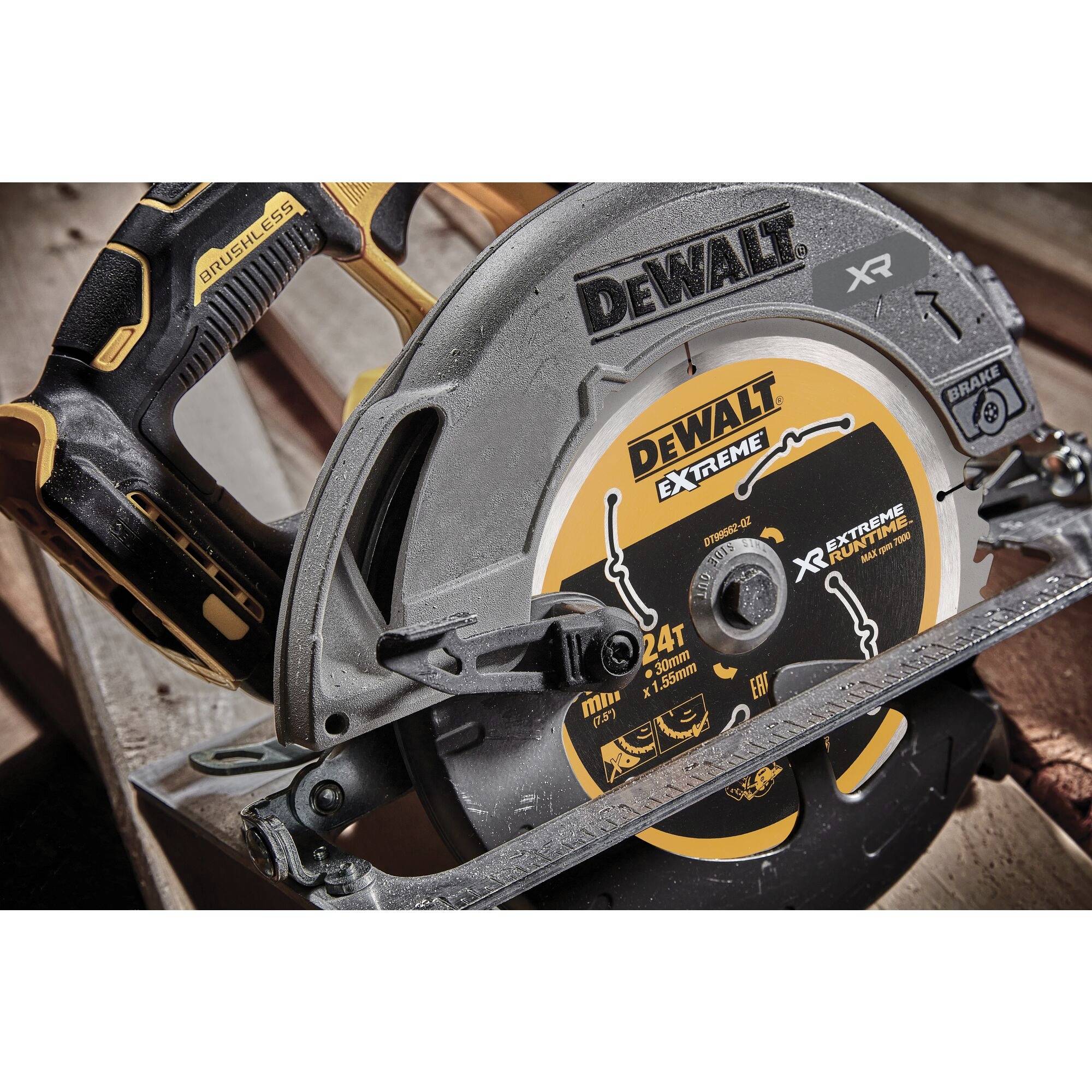 Na stole je umístěna elektrická pila značky DeWalt. Pila má nápis 'Dewalt Extreme' a je v charakteristických černo-žlutých barvách.