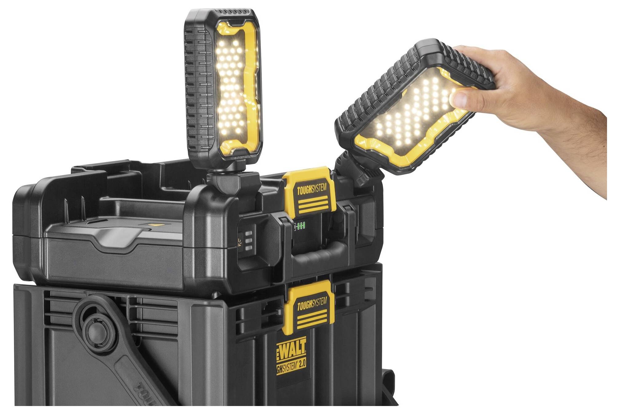 Ruka umisťuje LED lampu Dewalt na robustní černou přenosnou nářaďovou skříň. Scéna ukazuje možnosti použití přenosného osvětlení.