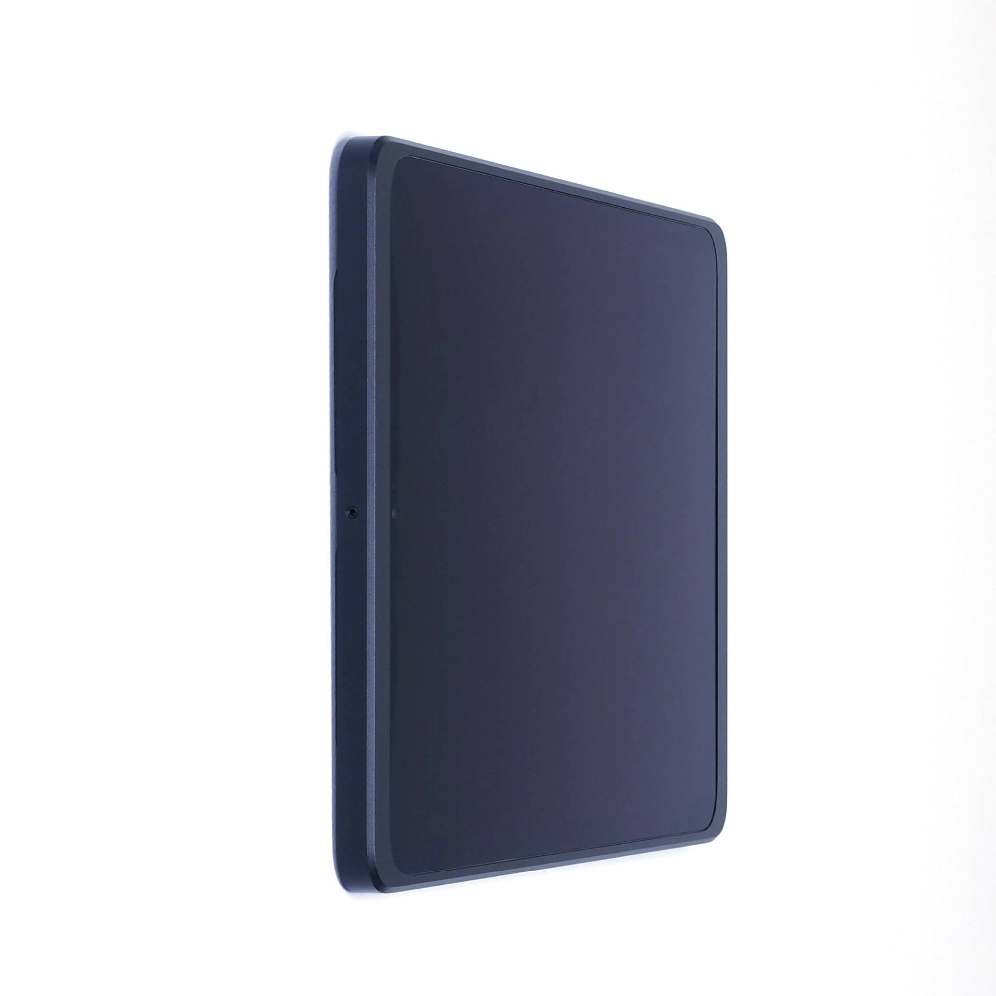 Moderní tablet s tmavým displejem je umístěn do strany před jednoduchým světlým pozadím.