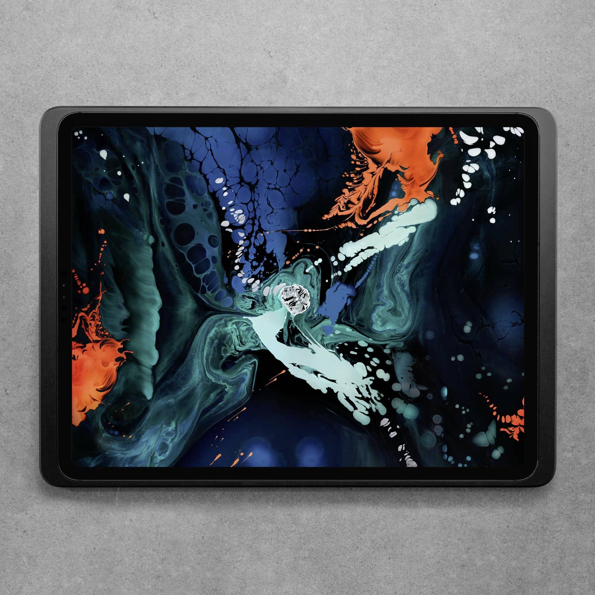 Tablet s abstraktním uměleckým dílem v modro-oranžových tónech na šedém pozadí.