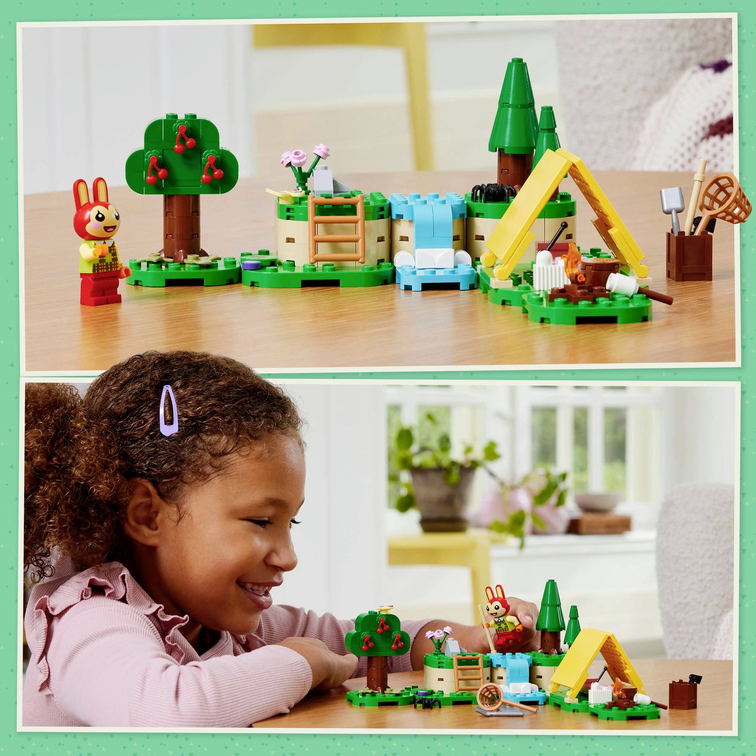 Dítě si hraje s LEGO soupravou znázorňující tábořiště s lesem, řekou a zvířaty, přičemž se usmívá a soustředěně se věnuje stavbě.