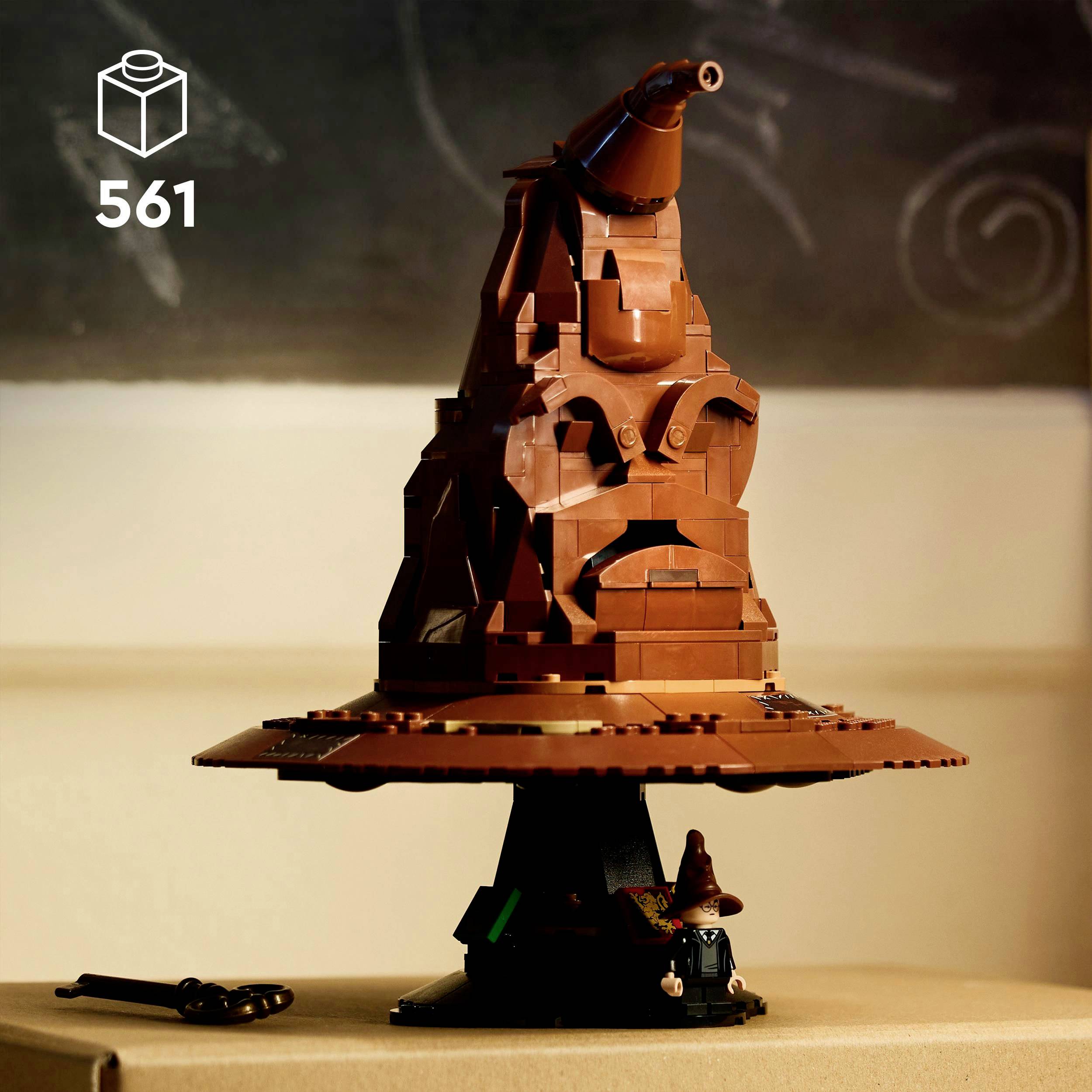 Hnědý LEGO domeček na kruhovém podstavci, který se podobá kouzelnickému klobouku, s detailní strukturou v pozadí před tabulí.
