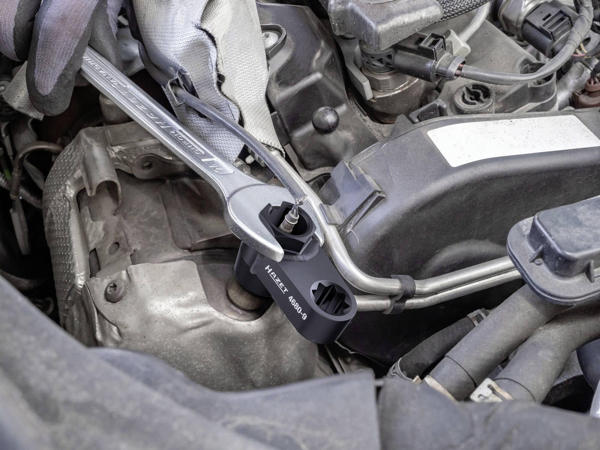 Momentový klíč se používá k utažení matice na motoru automobilu. Je nasazen speciální adaptér.