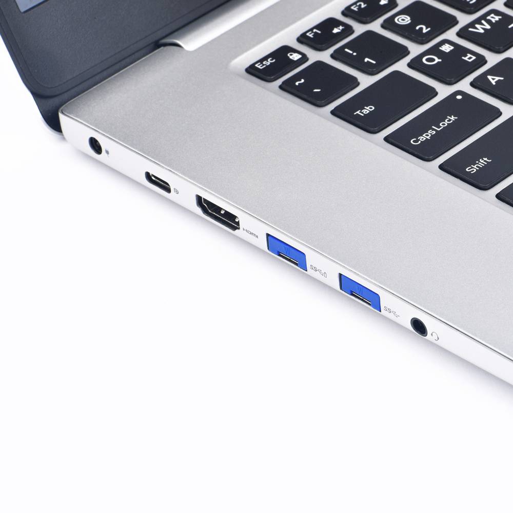Stříbrný notebook s černou klávesnicí, pohled z boku. Viditelné jsou USB porty, HDMI výstup a konektor pro sluchátka.