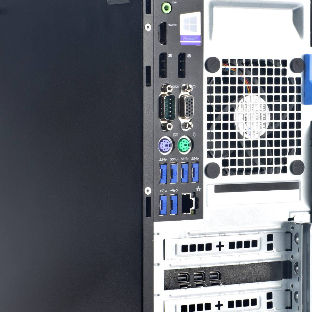 Zadní strana počítače s několika porty: USB, HDMI, síťové konektory a větrací mřížky. Horní část zobrazuje logo Windows.