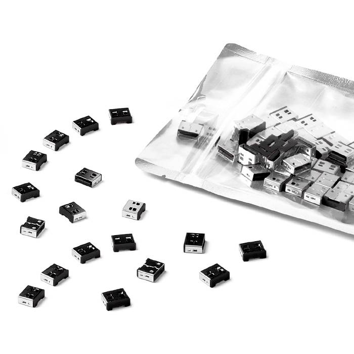 Několik USB donglu rozmístěných vedle otevřené krabice obsahující mnoho identických donglu.