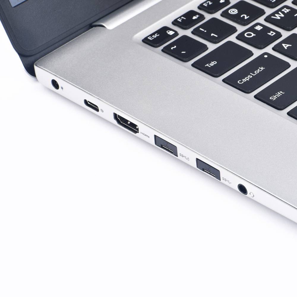 Laptop se stříbrným povrchem a černými klávesami, zobrazující konektory na boku, včetně USB a HDMI.
