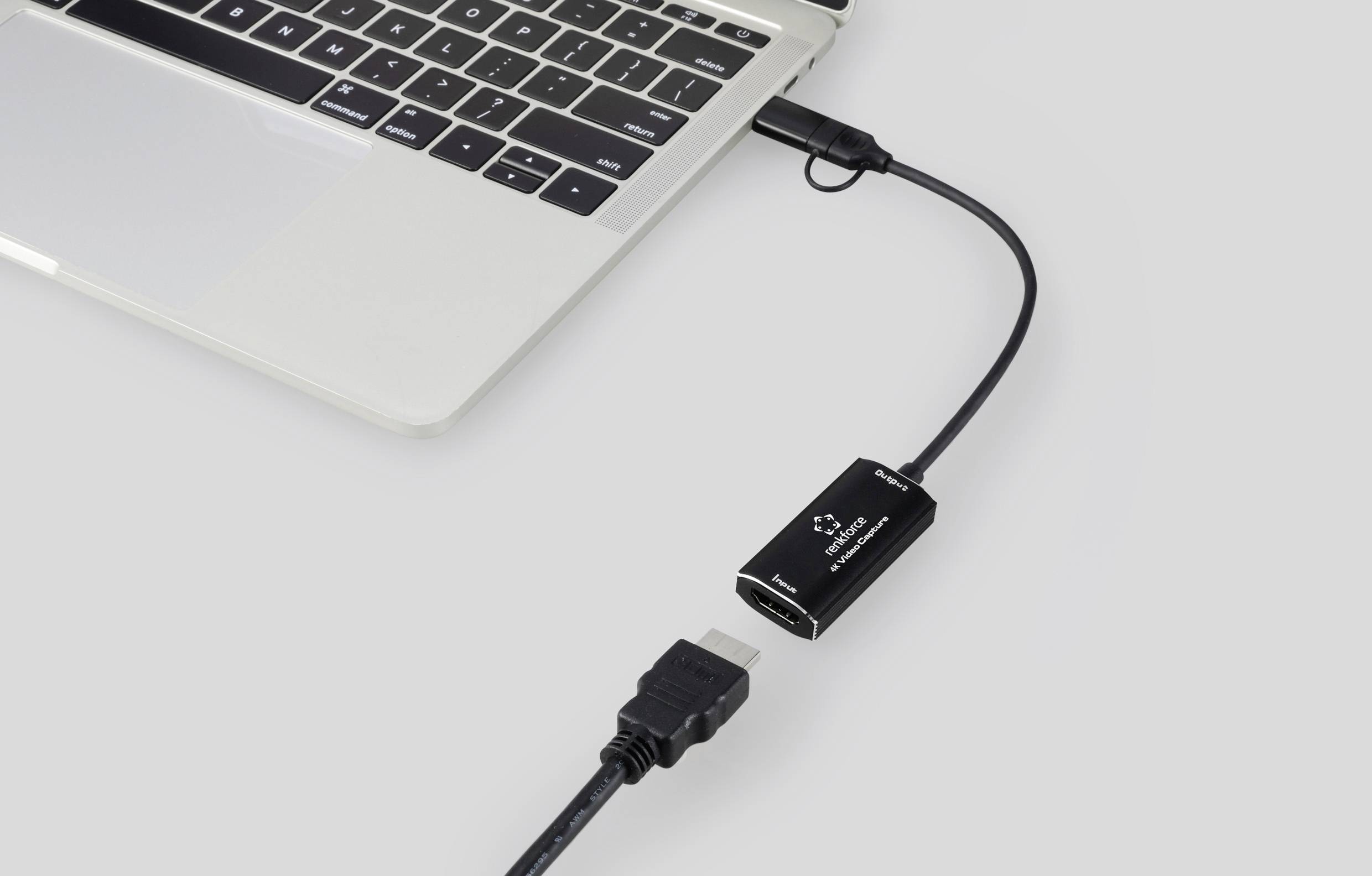 Laptop připojený k adaptéru HDMI kabelu. Adaptér přeměňuje HDMI signály pro laptop.