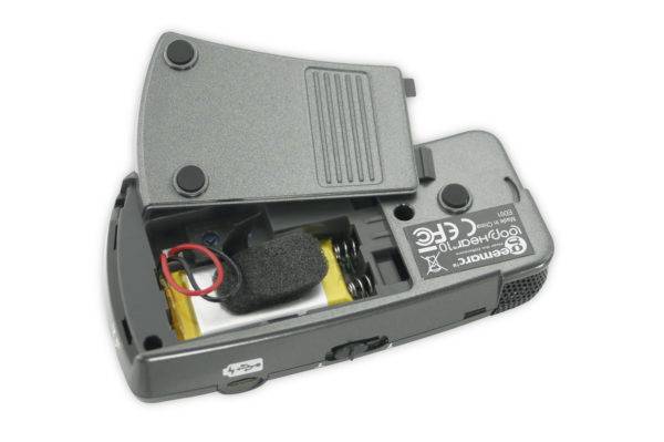 Otevřené elektronické zařízení s odhalenými vnitřními komponenty, včetně baterie a drátů, na bílém pozadí.