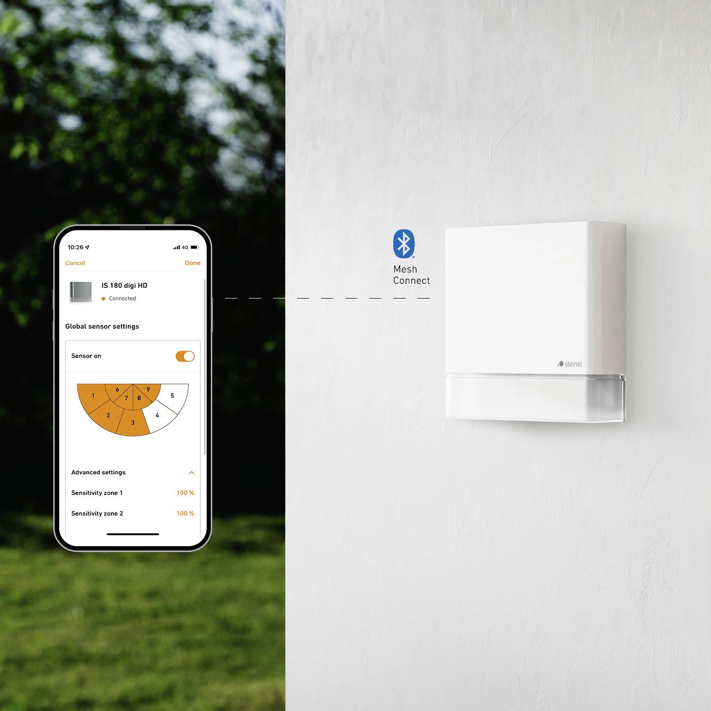 Smartphone zobrazuje aplikaci pro ovládání termostatu vedle bílého nástěnného termostatu. Připojení přes Bluetooth Mesh.