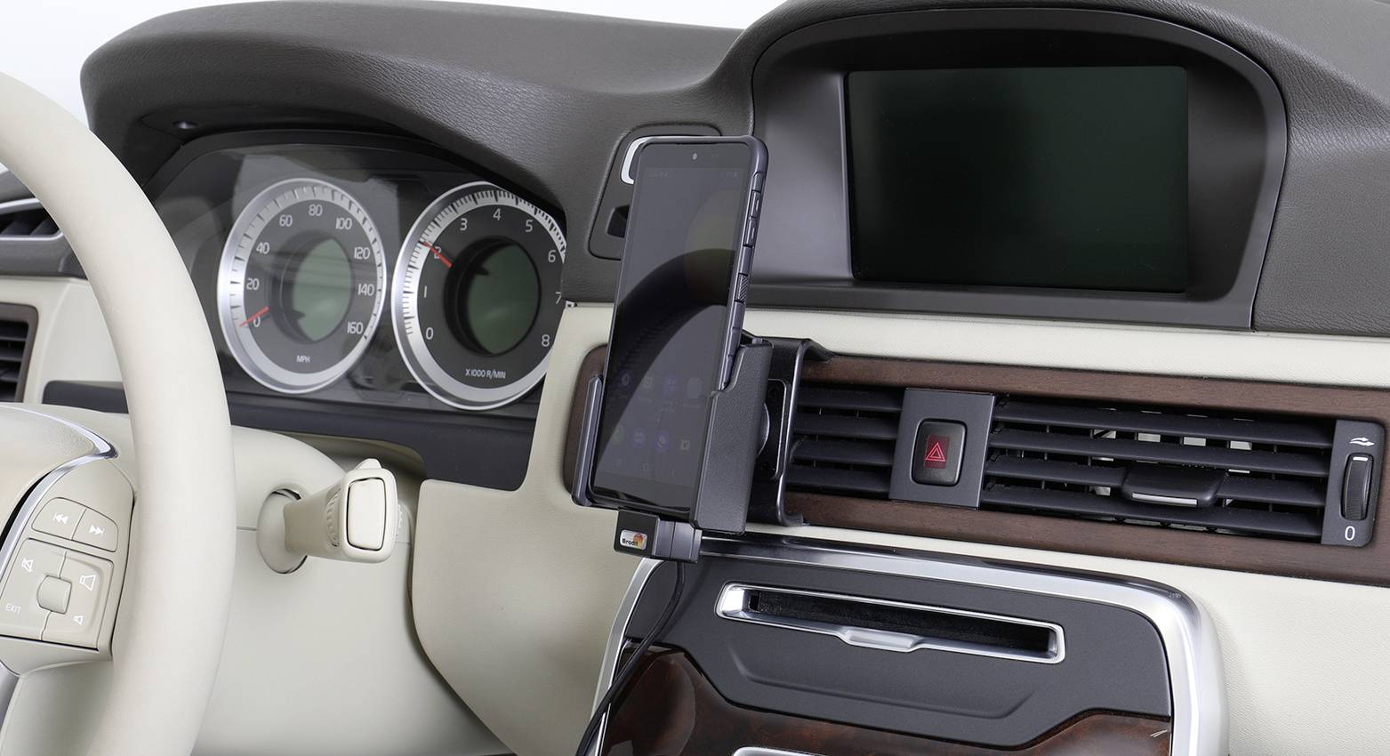 Vnitřek automobilu s držákem na smartphone připevněným k ventilaci. Telefon zobrazuje navigační aplikaci. Přístrojová deska je viditelná.