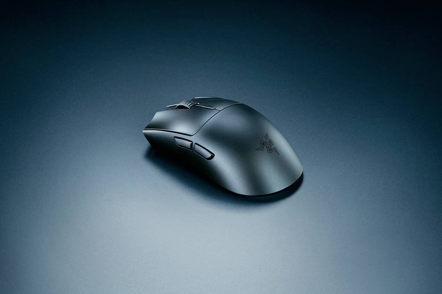Bezdrátová herní myš na tmavém, jednotném povrchu. Ergonomický design s jemnými konturami a několika tlačítky.