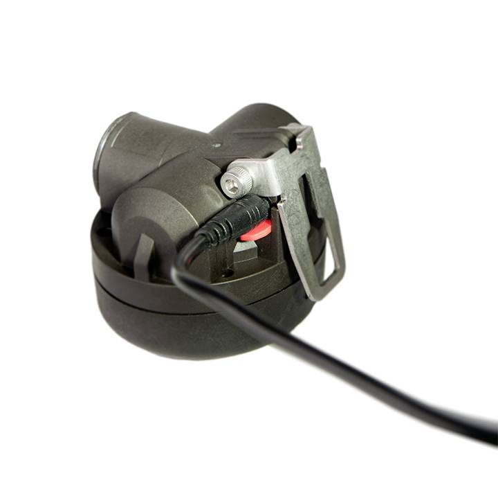 Černé zařízení s kabelovým připojením a kovovým klipem. Kabel je zapojen a směřuje dopředu.