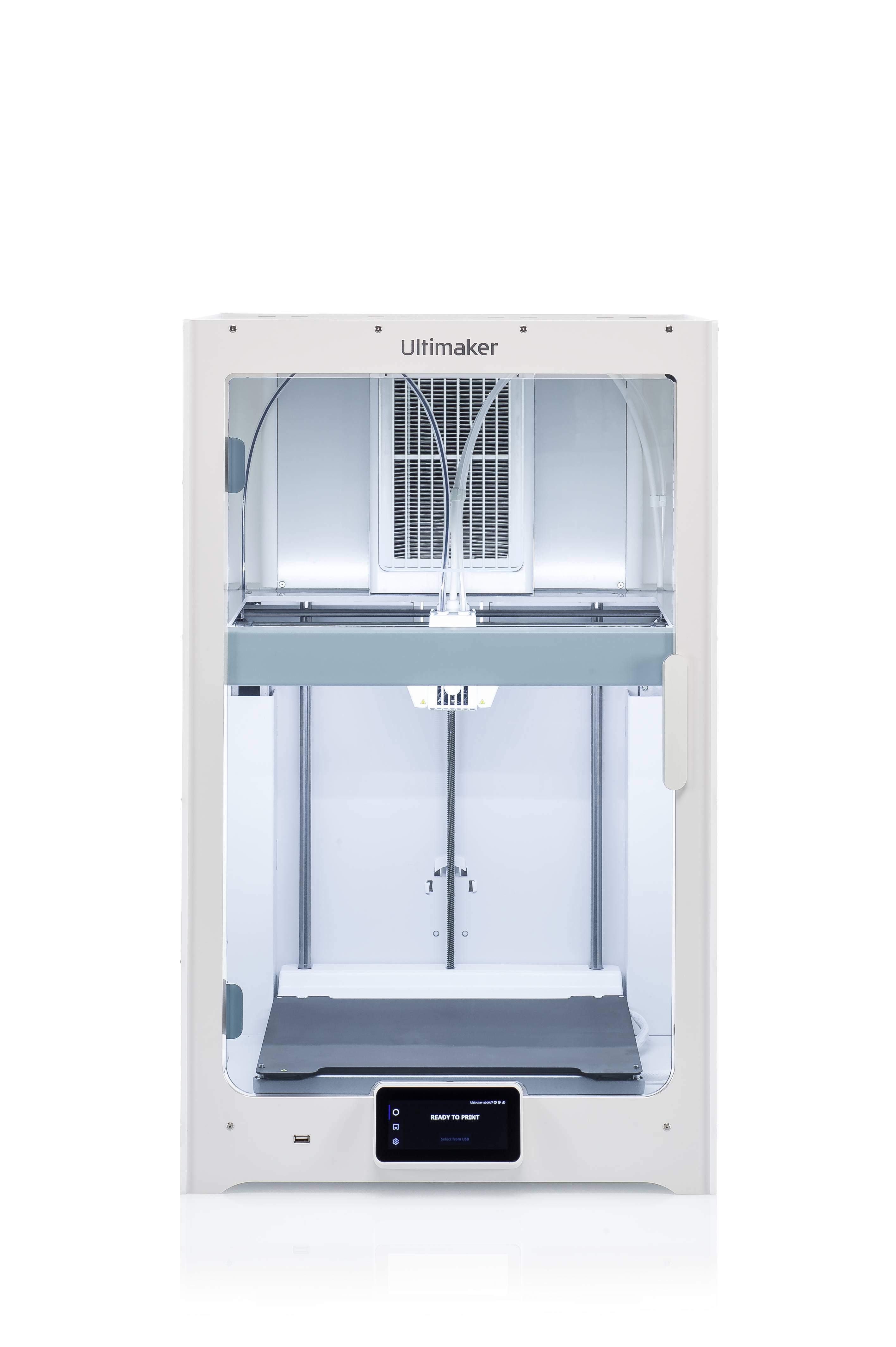 Bílá 3D tiskárna Ultimaker, zobrazená čelně. Moderní design s osvětleným vnitřním prostorem a digitálním displejem dole.