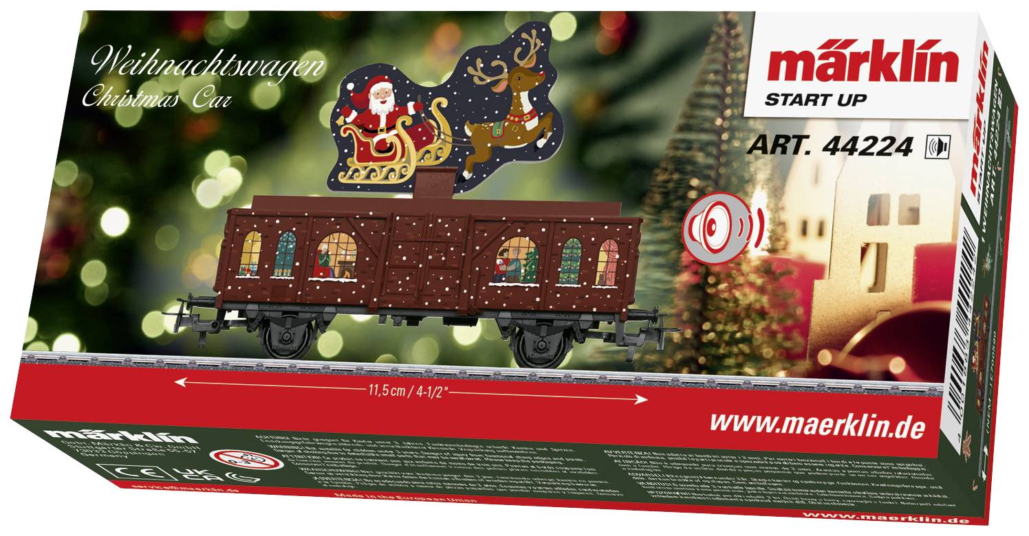 Vánoční vůz - modelová kolejová souprava v obalu s obrázkem železničního vozu, který zobrazuje Santa Clause v saních tažených soby.