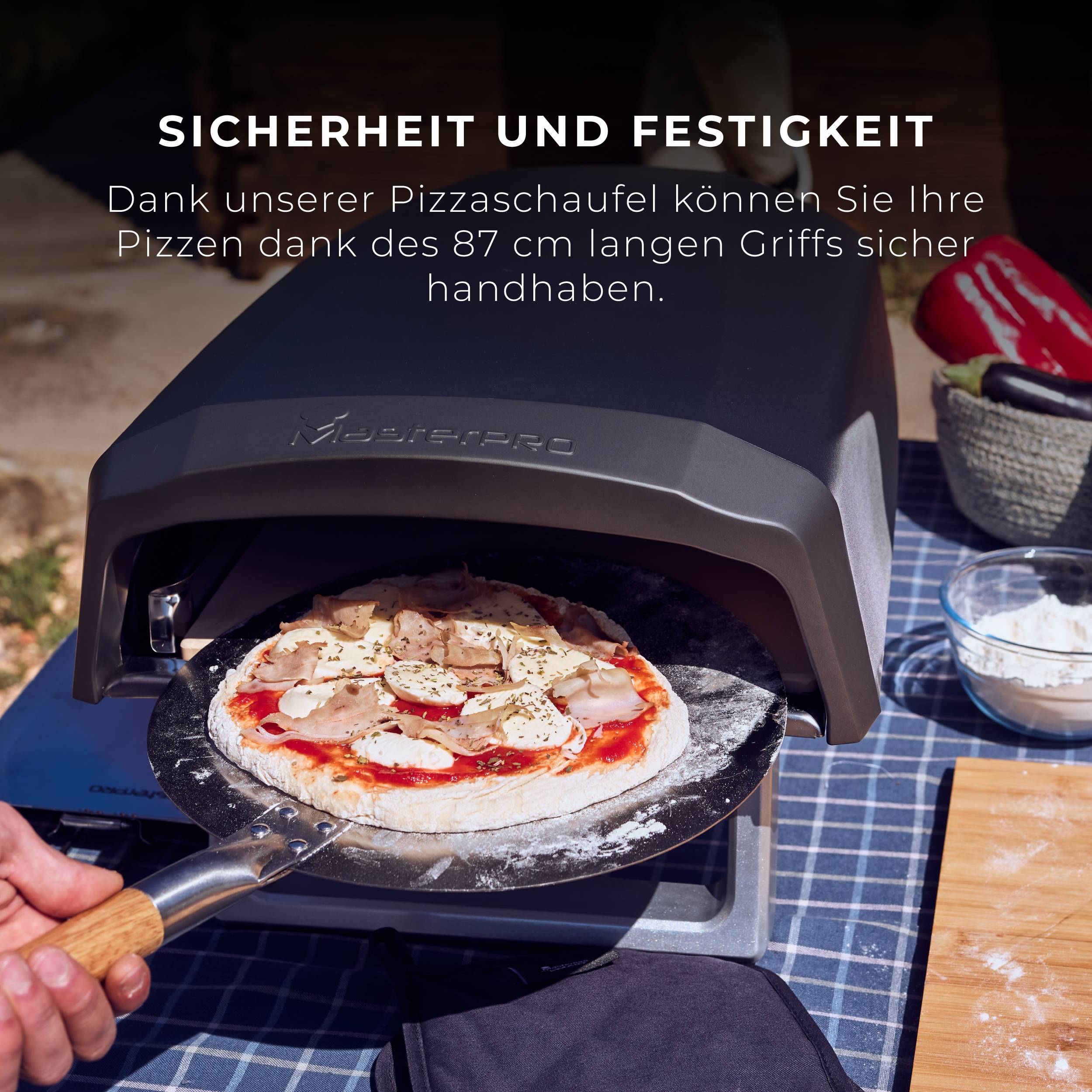 Jedna osoba vkládá pizzu lopatkou do pece. Text zdůrazňuje bezpečnost a stabilitu lopaty.