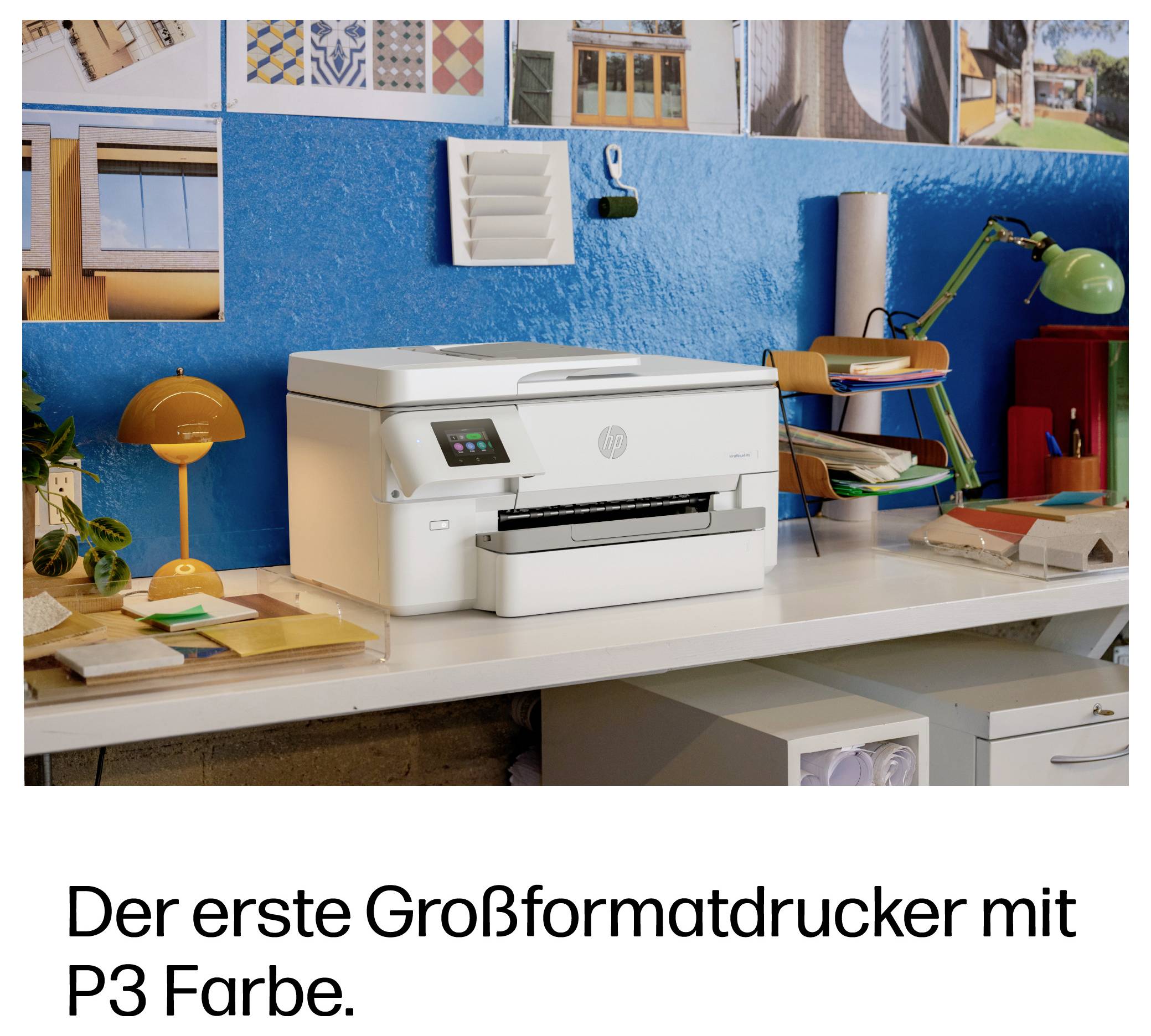 Bílá tiskárna HP velkého formátu na stole v barevném pracovním prostoru s německým textem níže, který zní „Der erste Großformatdrucker mit P3 Farbe."<br><br>Translation of German text: "První velkoformátová tiskárna s barvou P3."