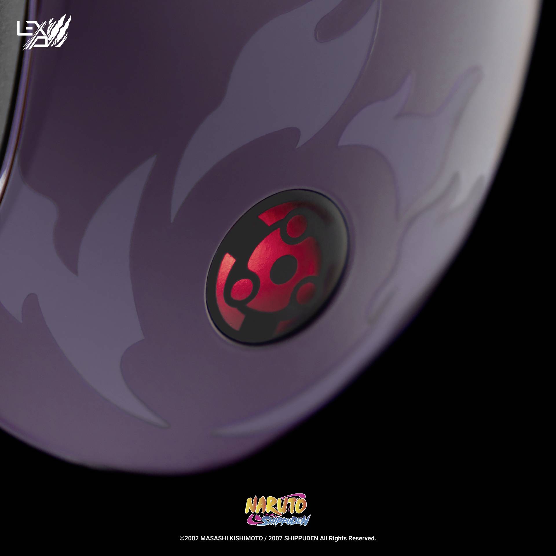 Detailní záběr fialového předmětu s červeným světélkujícím symbolem uprostřed. Design inspirovaný seriálem 'Naruto Shippuden'.