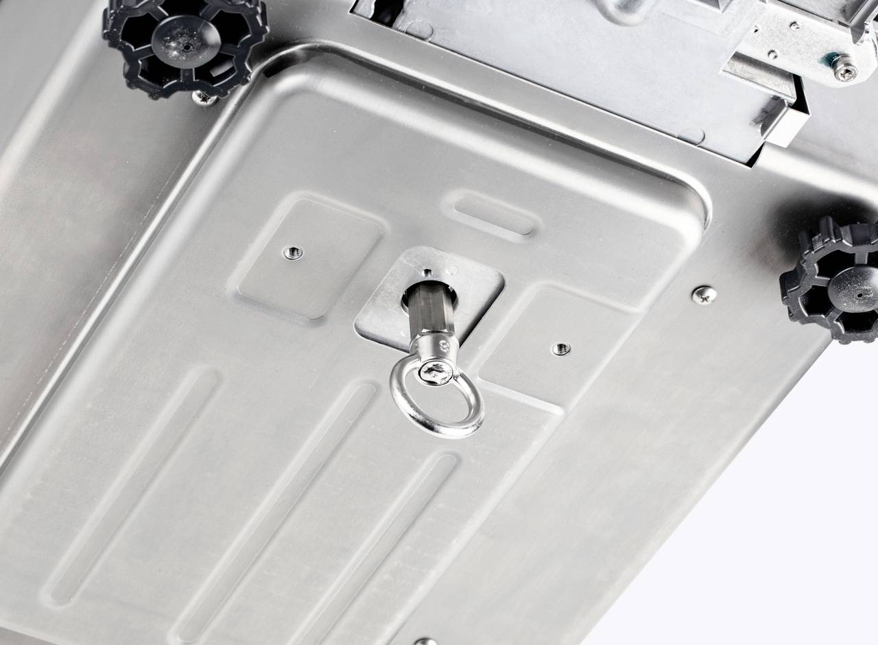 Kovový box se spodní stranou s klíčem v zámku. Dva černé otočné knoflíky se nacházejí v rozích.