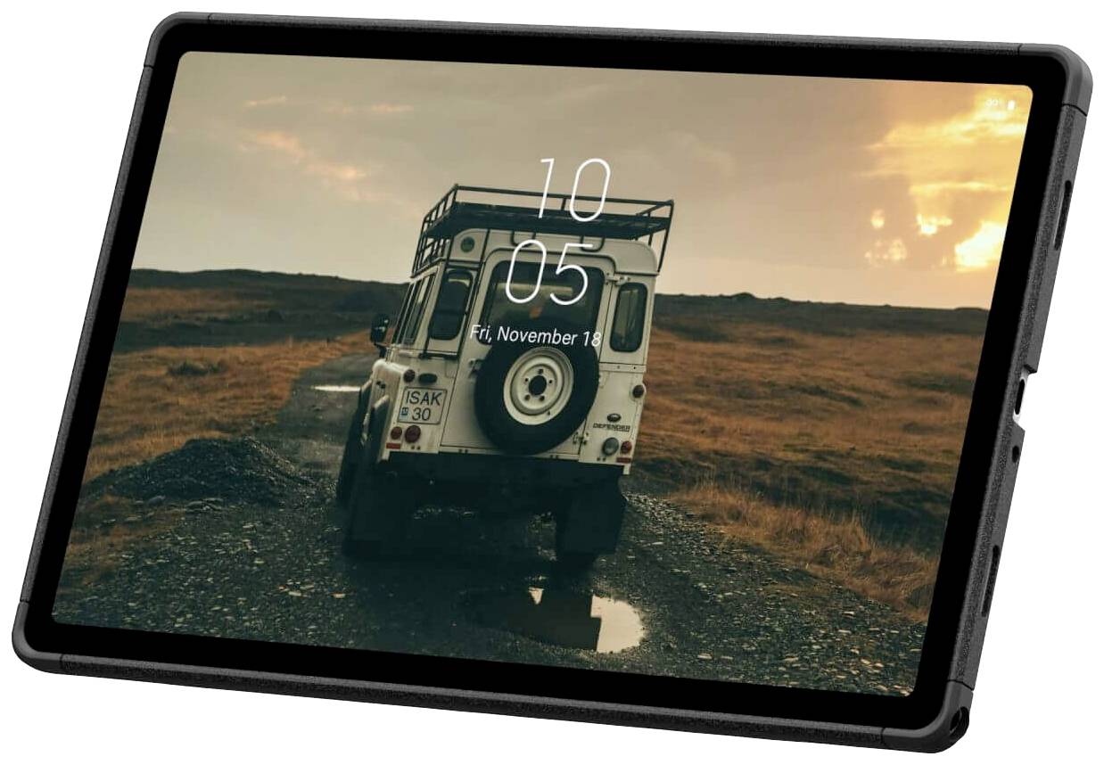 Tablet zobrazuje obrázek bílého terénního vozu na štěrkové cestě ve venkovské krajině za soumraku.