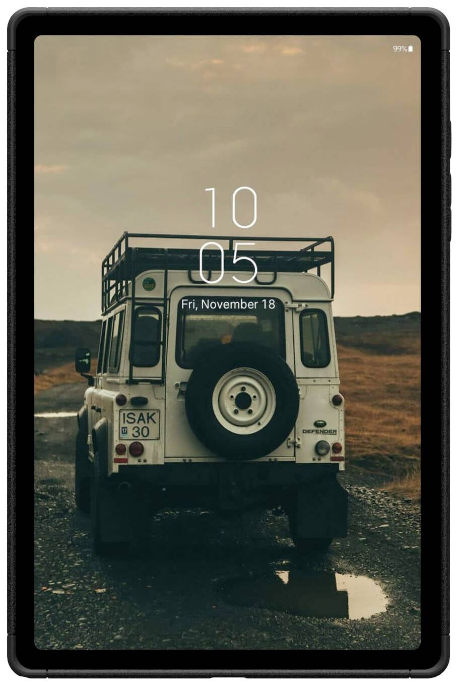 Terénní vůz s náhradním kolem na venkovské cestě; večerní atmosféra. Tablet zobrazuje čas '10:05' a datum 'pátek, 18. listopadu'.