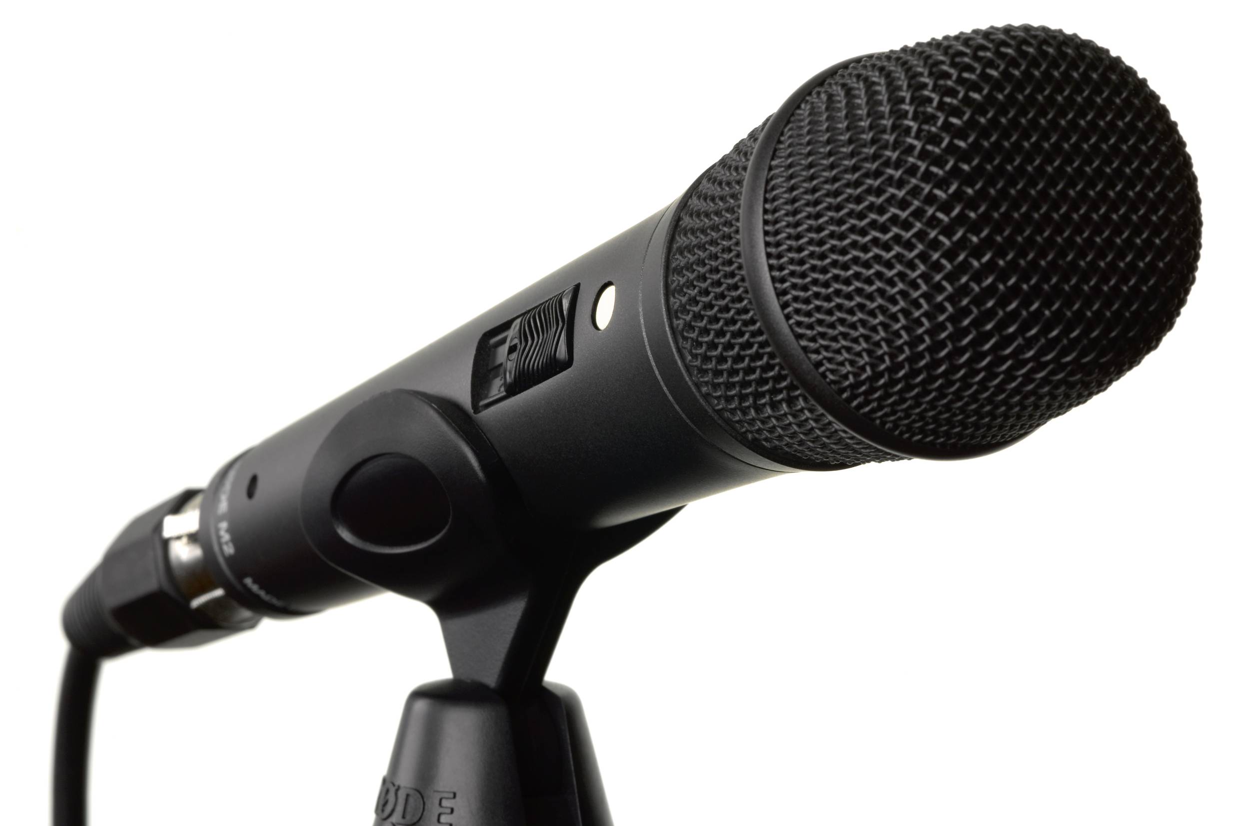 Černý mikrofon na stojanu, připravený pro nahrávání nebo prezentaci.
