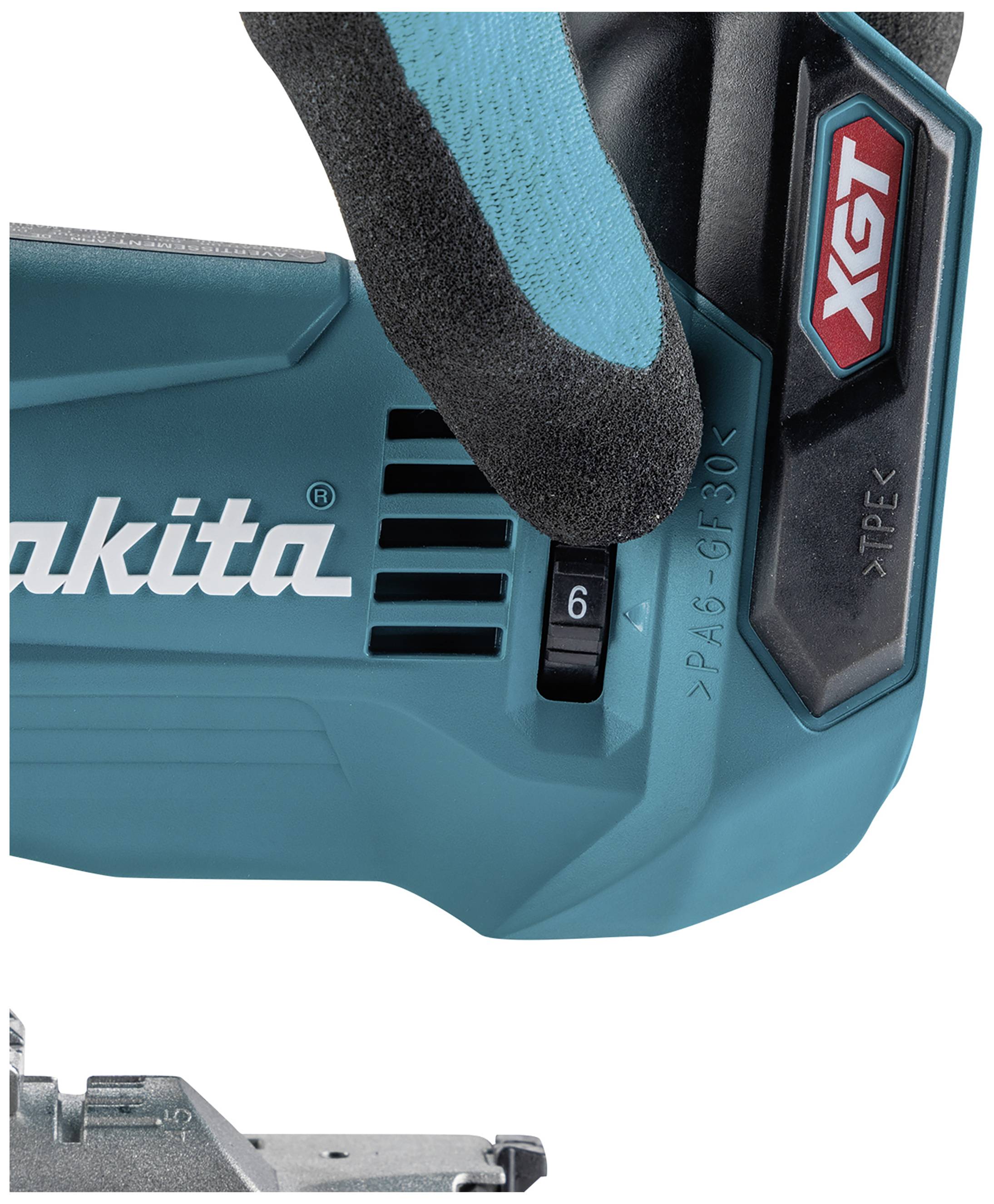 Elektrikářský nástroj v tyrkysové barvě s černou rukojetí, částečně držený rukavicí opatřené ruky. Nápis: 'Makita' a 'XGT'.