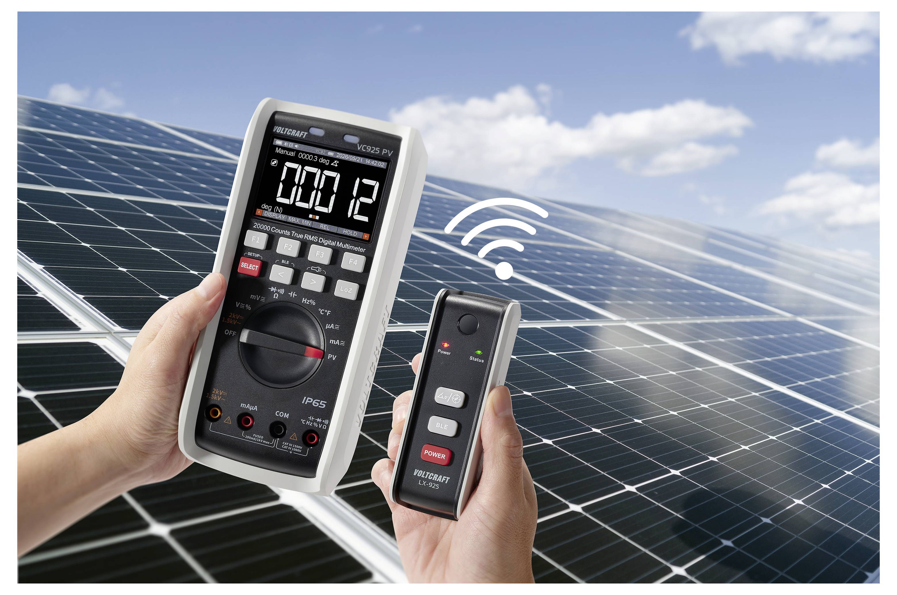 Ruce držící digitální multimetr a bezdrátový senzor nad solárními panely, ukazující testování a monitorování fotovoltaického systému.