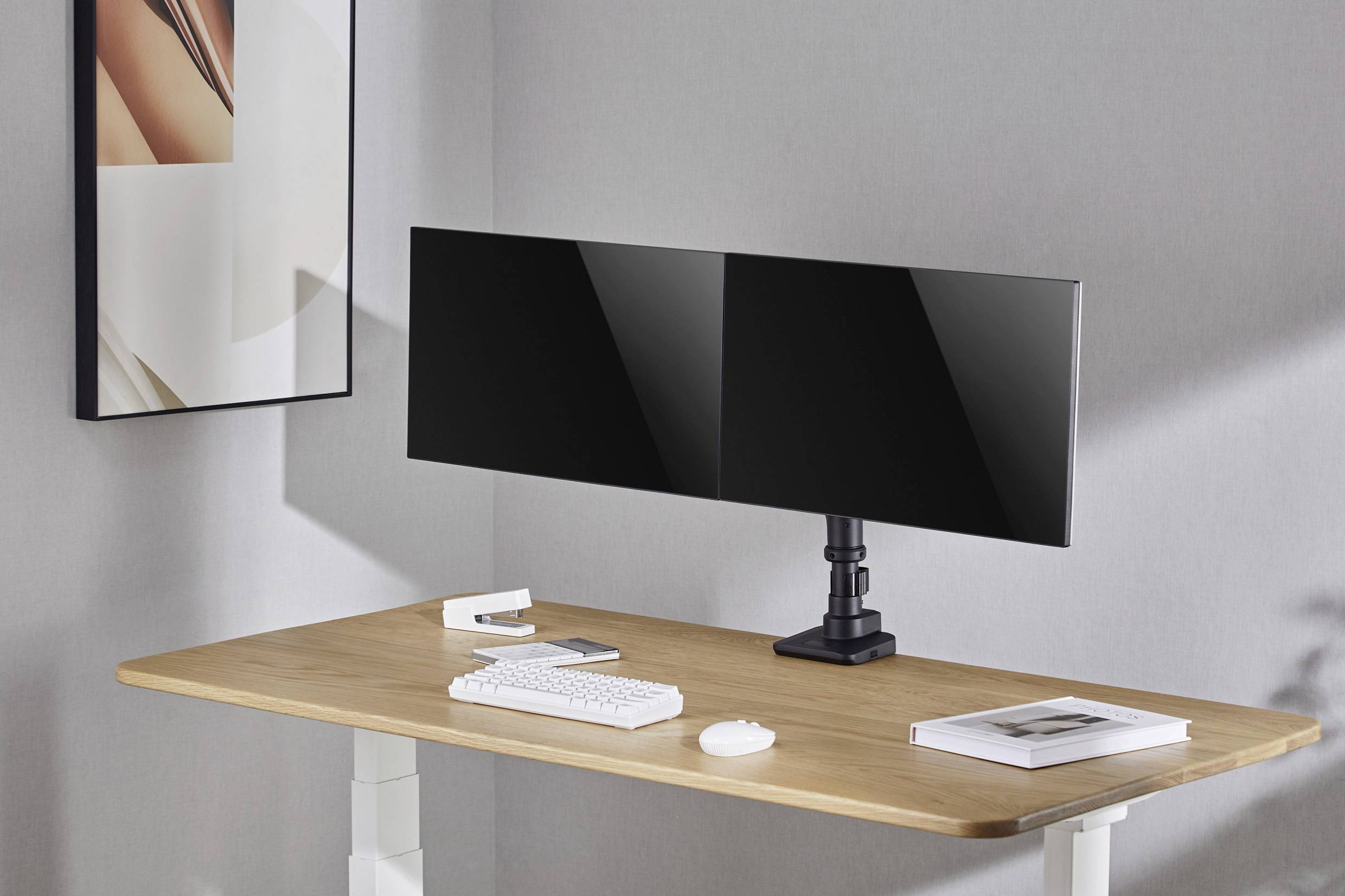 Moderní domácí kancelář s velkým, dvoumontitorovým pracovištěm na dřevěném stole, klávesnicí a myší, s minimalistickým designem.