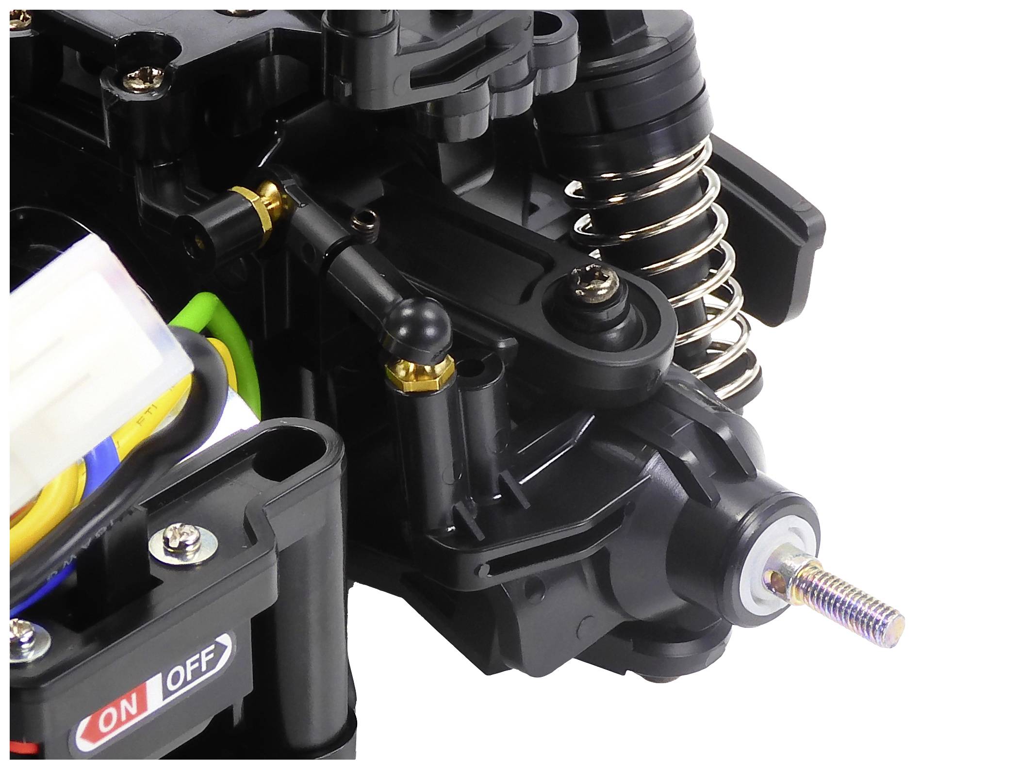 Detailní záběr části RC modelu automobilu s tlumiči, šrouby a vypínačem 'ON/OFF'. Obrázek zobrazuje technické detaily a strukturu.