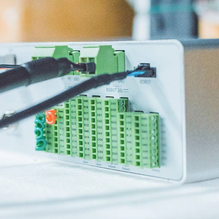 Zelený spínací modul s několika kabelovými přípojkami a sloty v zaostření. Spínací obvod pro technické nebo průmyslové použití.