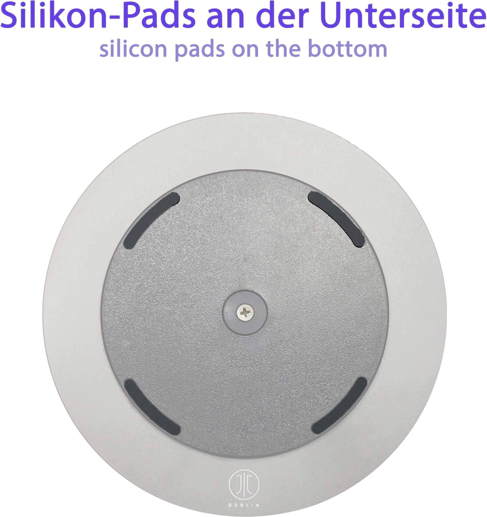 Kulatý předmět s silikonovými podložkami na spodní straně, na kterém je fialově napsán text 'Silikonové podložky na spodní straně'.