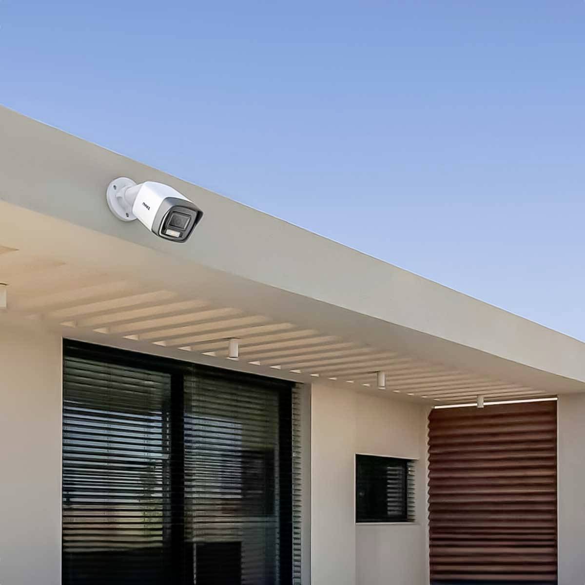 Bezpečnostní kamera je nainstalována na vnější straně moderní budovy pod modrým nebem.