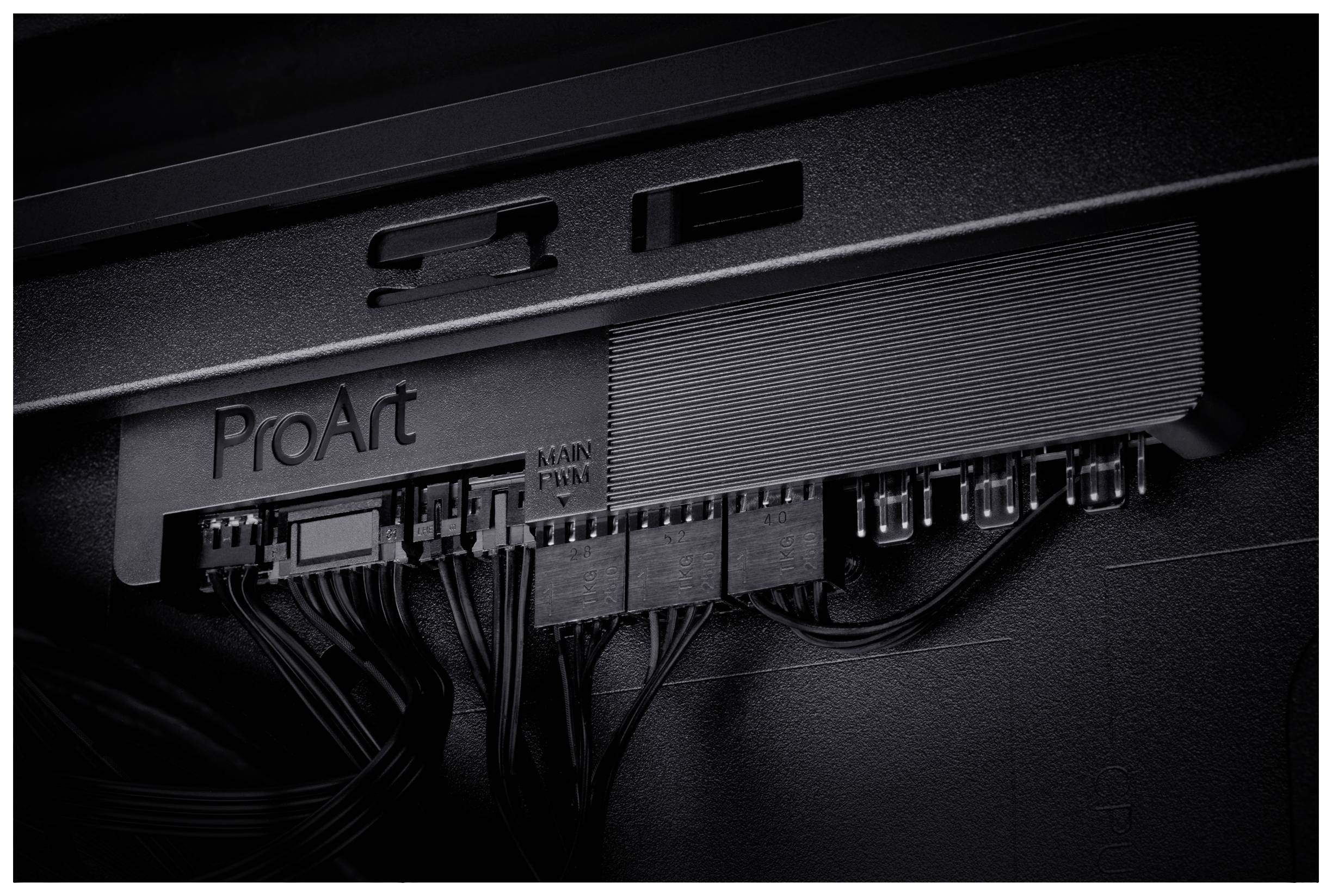 Elektronická součástka s nápisem 'ProArt', obklopená několika kabelovými konektory.
