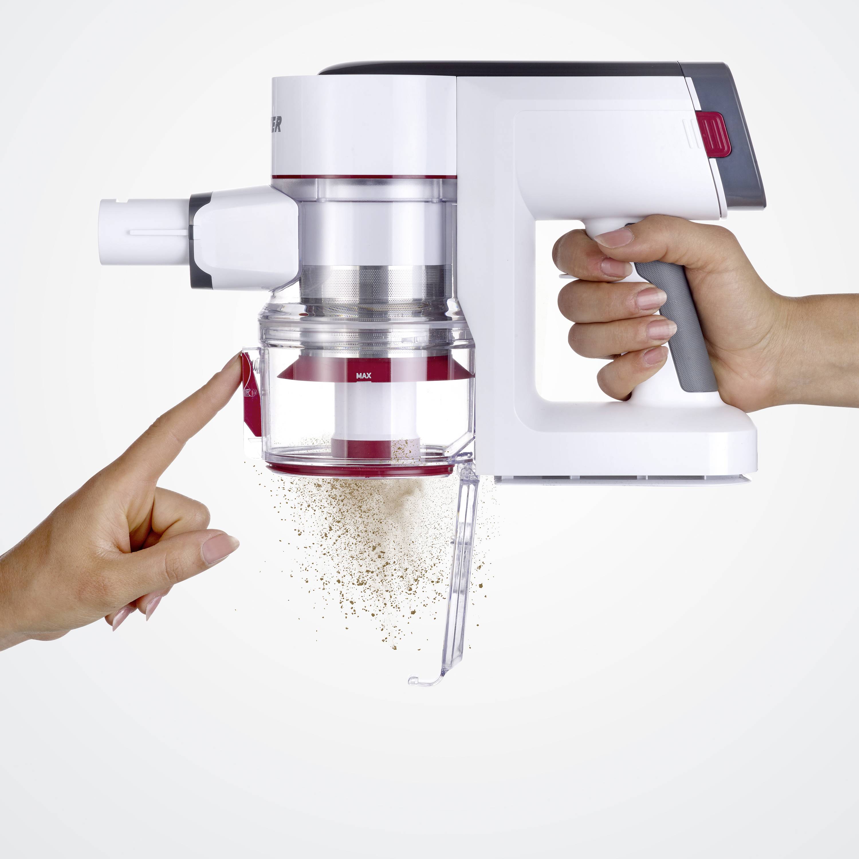 Jedna ruka drží vysavač, zatímco druhá ruka ukazuje na částečně prázdnou nádobku na prach. Prach z ní vypadává.