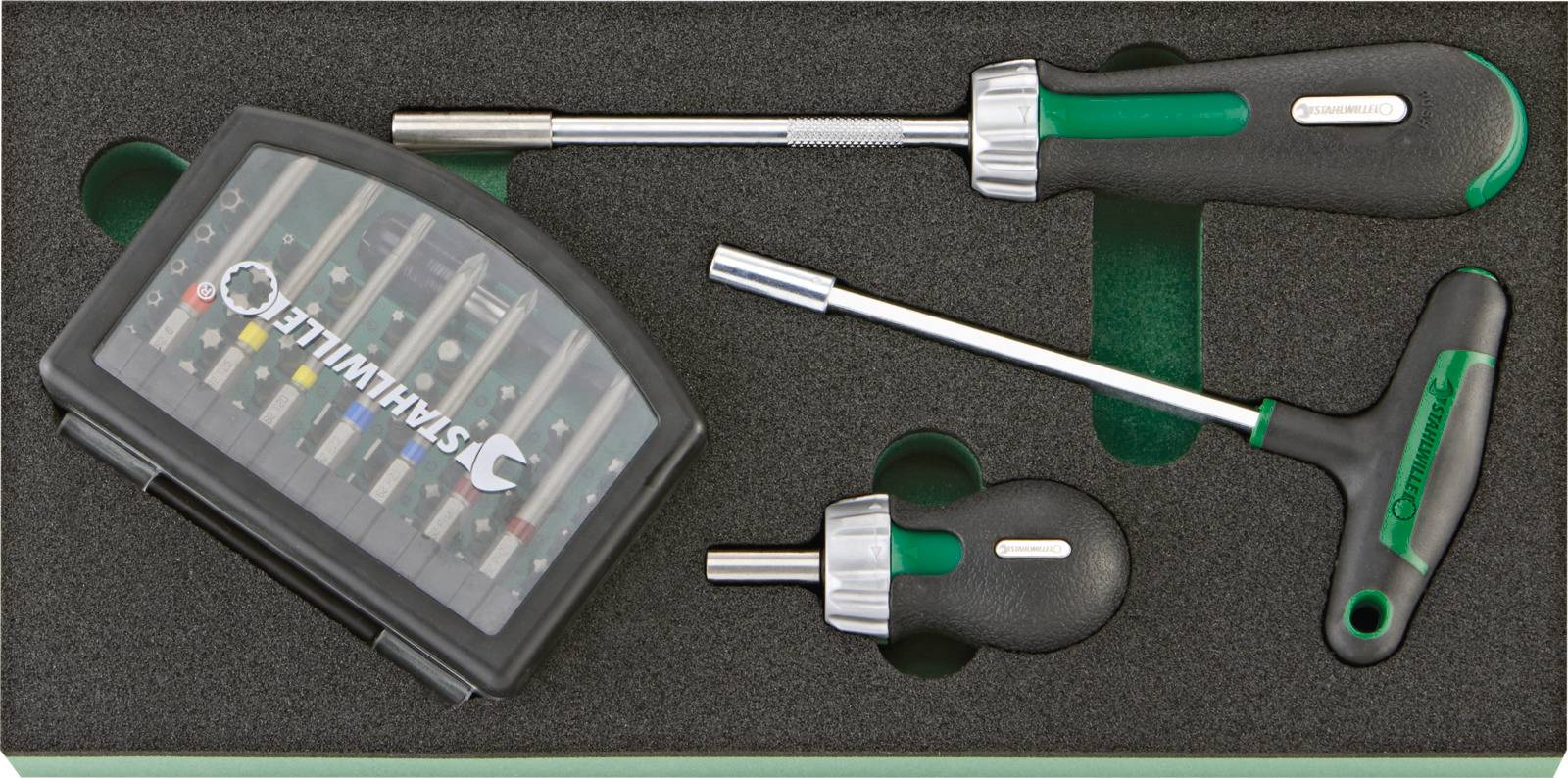 Sada šroubováků s různými nástavci v černém kufříku na nářadí. Obsahuje několik šroubováků se zelenými rukojeťmi.