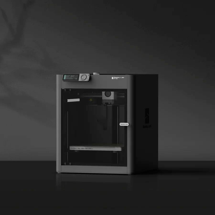 3D tiskárna stojí na stole před tmavým pozadím. Zařízení má světlý displej a skleněné dvířka.