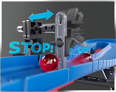 Hračkářská kuličková dráha s dopravními značkami Stop a Jeď. Kulička stojí před stopkou; šipka ukazuje z „Stop" na „Jeď".