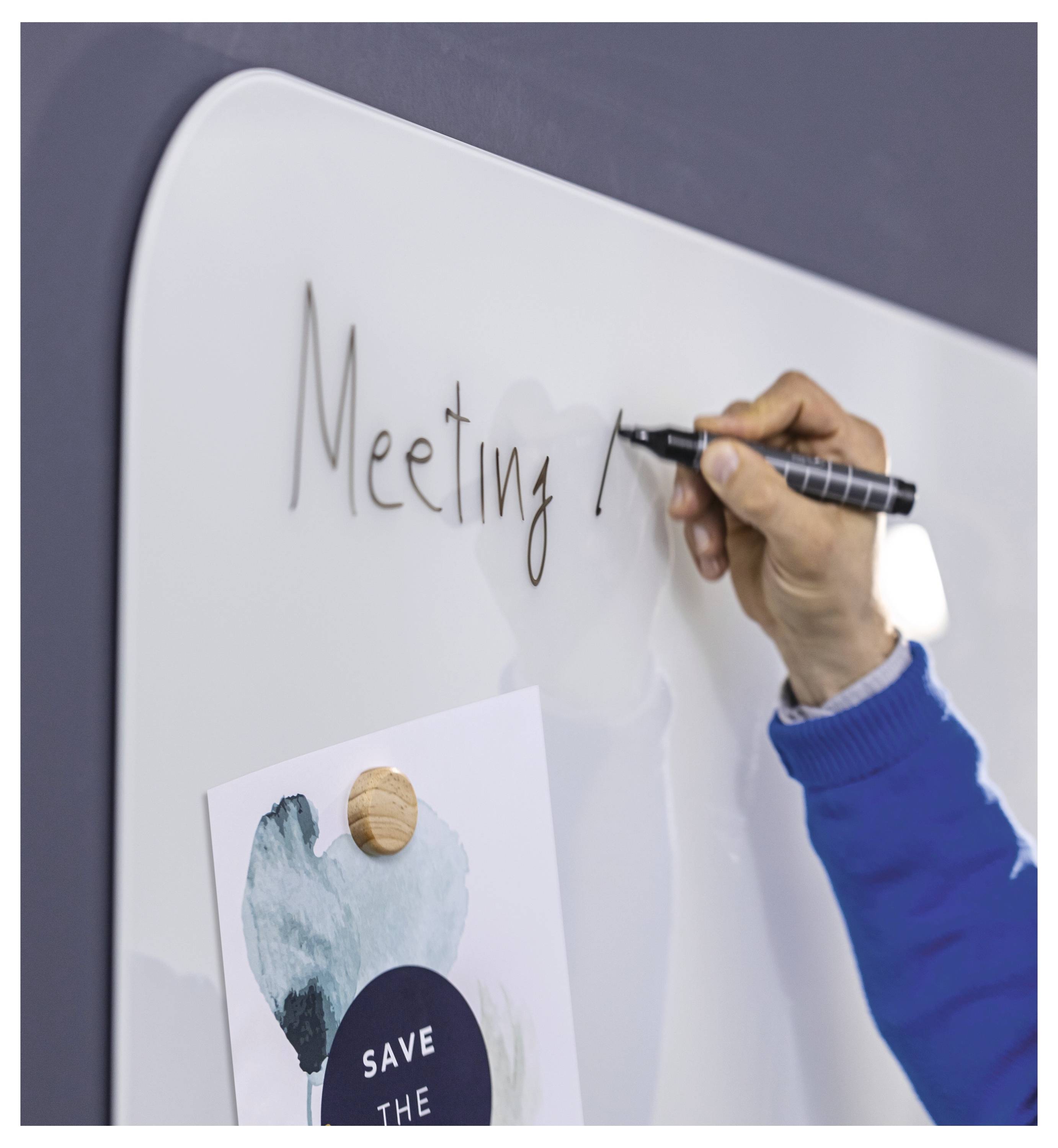 Písmo 'Schůzka' na tabuli vedle připnuté poznámky, což naznačuje plánování nebo brainstorming.