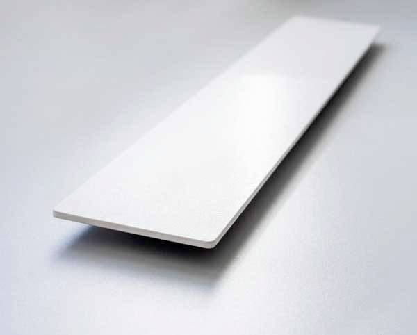Bílá obdélníková deska se vznáší nad šedou plochou pozadí. Minimalistický design, který klade důraz na materiál a tvar.