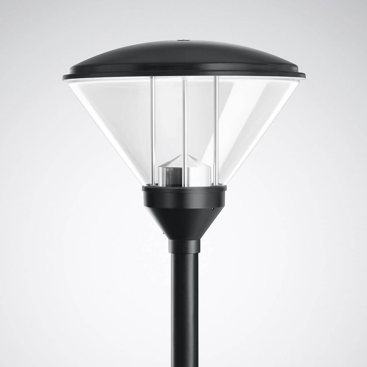 Moderní pouliční lampa s černým kovovým tělem a čirým sklem.