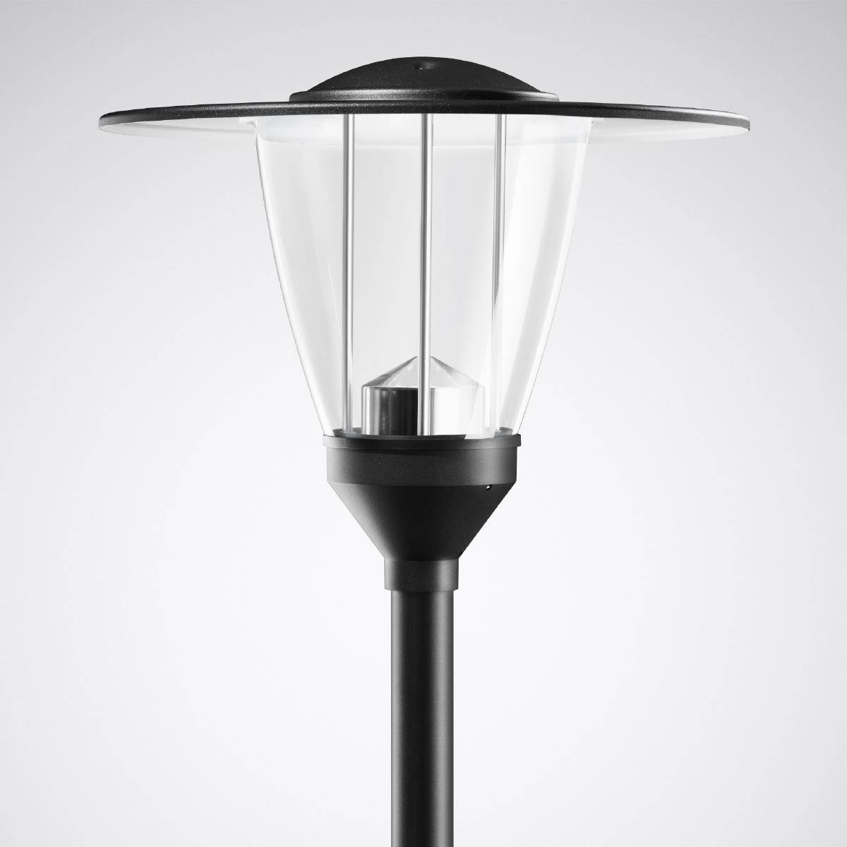 Moderní, černá pouliční lampa s průhledným skleněným stínítkem, která poskytuje osvětlení v městském prostředí.