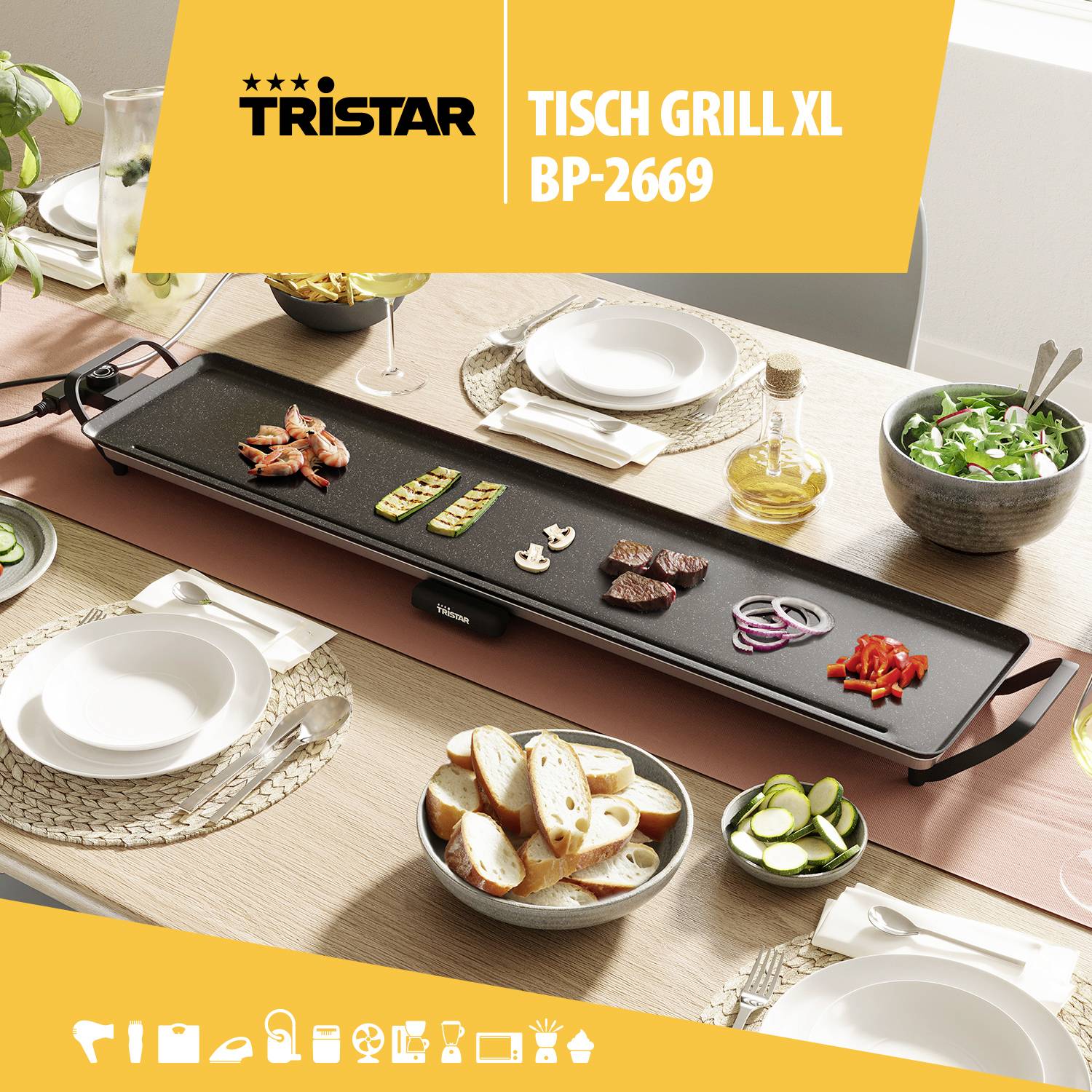 Stolní gril na prostřeném stole s zeleninou a chlebem. Vlevo nahoře je nápis 'Tristar Tisch Grill XL BP-2669'.