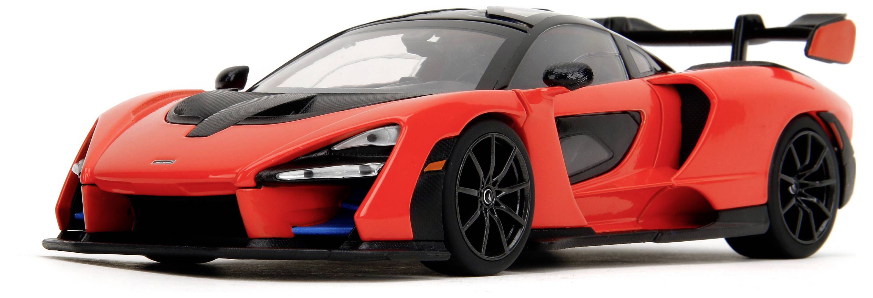 Červený sportovní vůz s černou střechou a spoilerem, zachycený z mírného předního pohledu. Auto má výrazné, aerodynamické tvary.